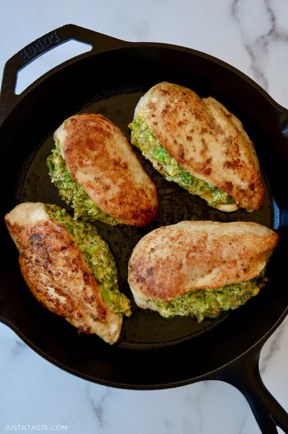 A cast-iron skilled with four stuffed chicken breasts