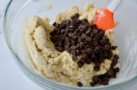 Bowl containing spatula and scone dough with chocolate chips