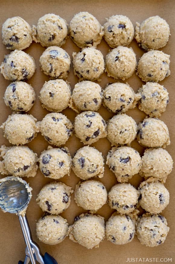 Rows of small scoops of edible cookie dough on brown parchment paper