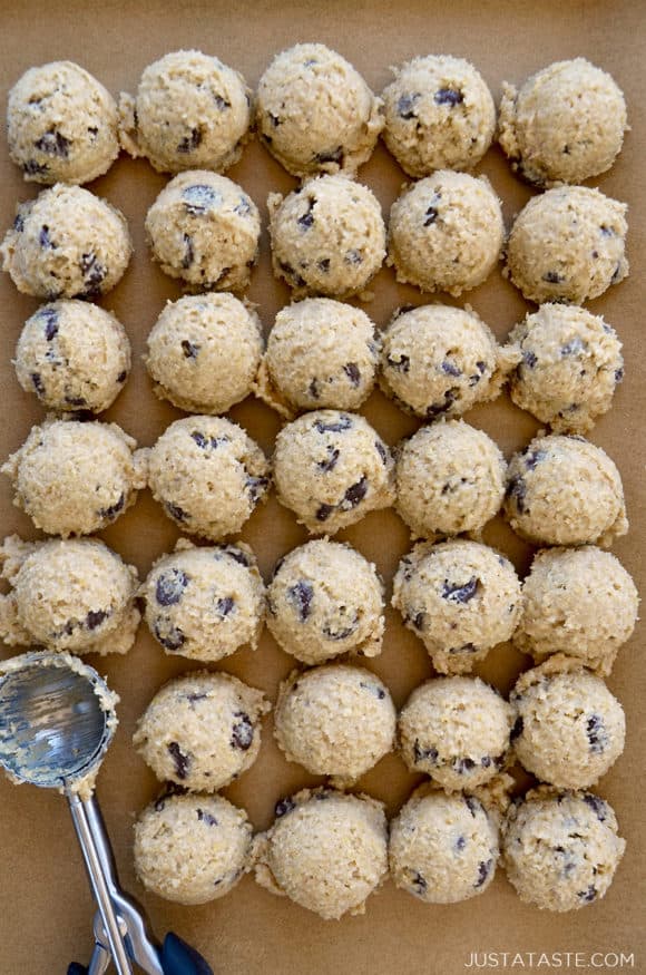 Rangées de petites boules de pâte à biscuits comestible sur papier parchemin brun