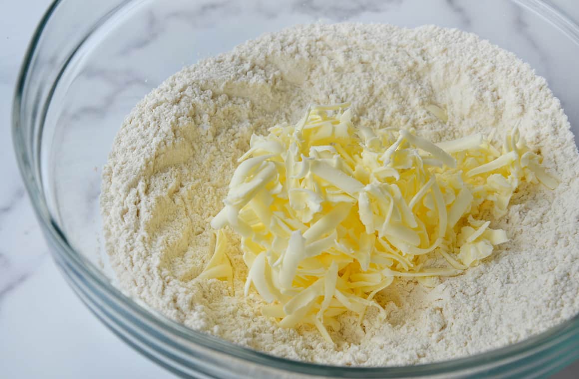Clear bowl containing flour and grated butter