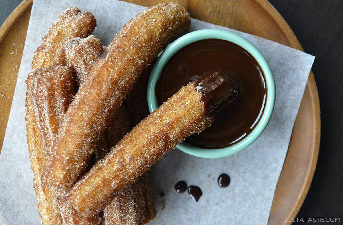 Top down view of easy homemade churros dunked in chocolate sauce.