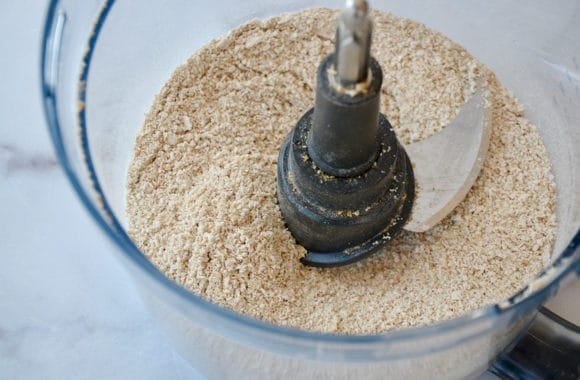 A food processor bowl containing oat flour