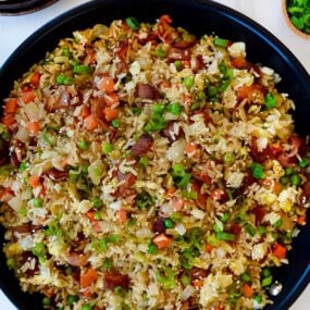 Large skillet containing bacon and egg fried rice