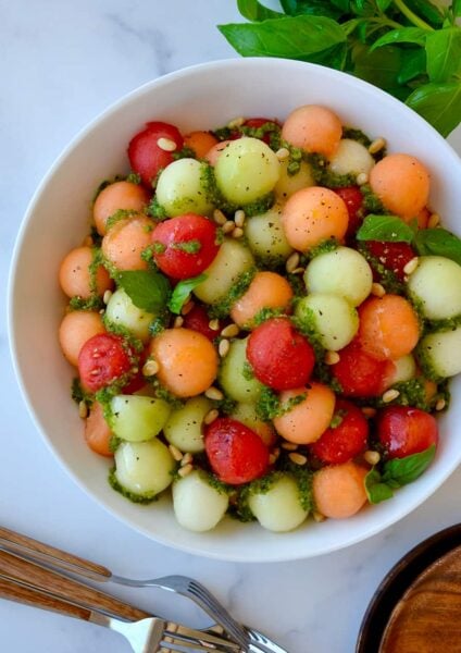 Top down view of white bowl containing easy melon salad with basil vinaigrette