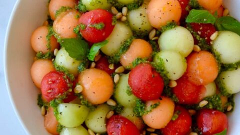 Top down view of white bowl containing easy melon salad with basil vinaigrette