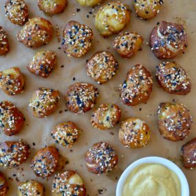 Brown parchment paper with soft pretzel bites topped with everything seasoning