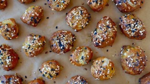 Brown parchment paper with soft pretzel bites topped with everything seasoning