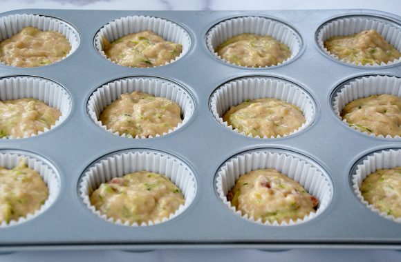 Muffin tin lined with paper filled with batter