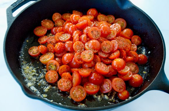 Sliced cherry tomatoes in large skillet with butter