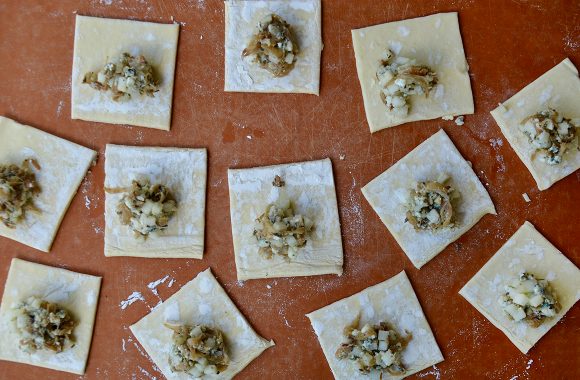 Squares of puff pastry with caramelized onions and sliced fruit