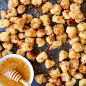 Baked Popcorn Chicken with Honey-Garlic Glaze topped with crushed red pepper flakes