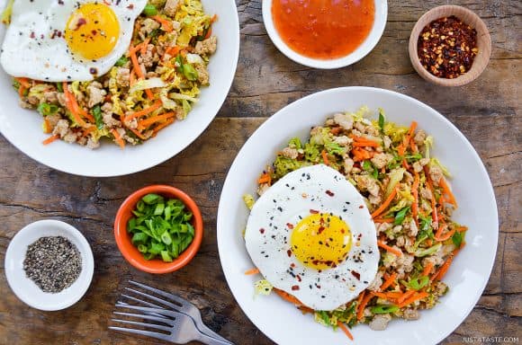 Easy healthy egg roll in a bowl topped with a fried egg next to dipping sauce and spices