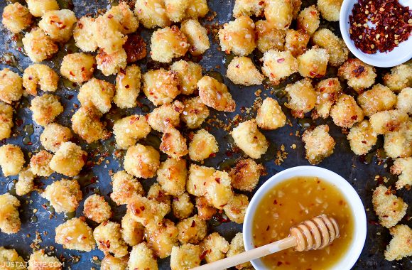 Easy baked popcorn chicken next to small ramekin with honey-garlic glaze