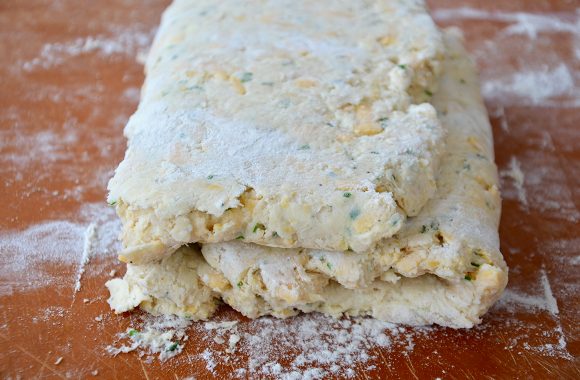 Layered biscuit dough on floured surface