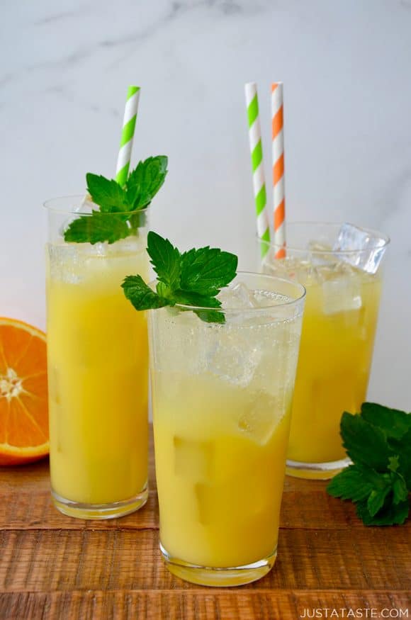 Three glasses containing orange and mango mocktails