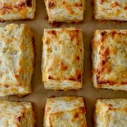 Rows of The Best Cheddar Biscuits on parchment paper-lined baking sheet