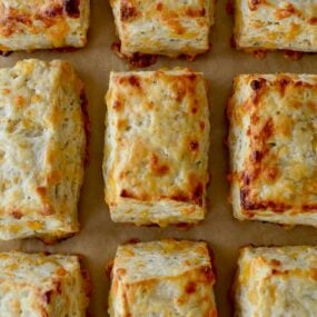 Rows of The Best Cheddar Biscuits on parchment paper-lined baking sheet
