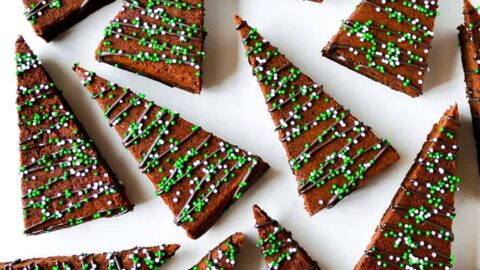 A top-down shot of Christmas tree-shaped brownies on a white surface