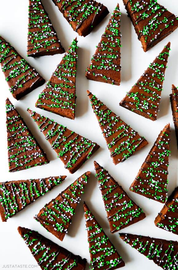 A top-down shot of Christmas tree-shaped brownies on a white surface