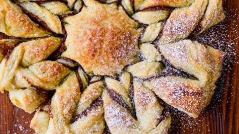 A top-down view of a puff pastry dessert dusted with confectioners' sugar