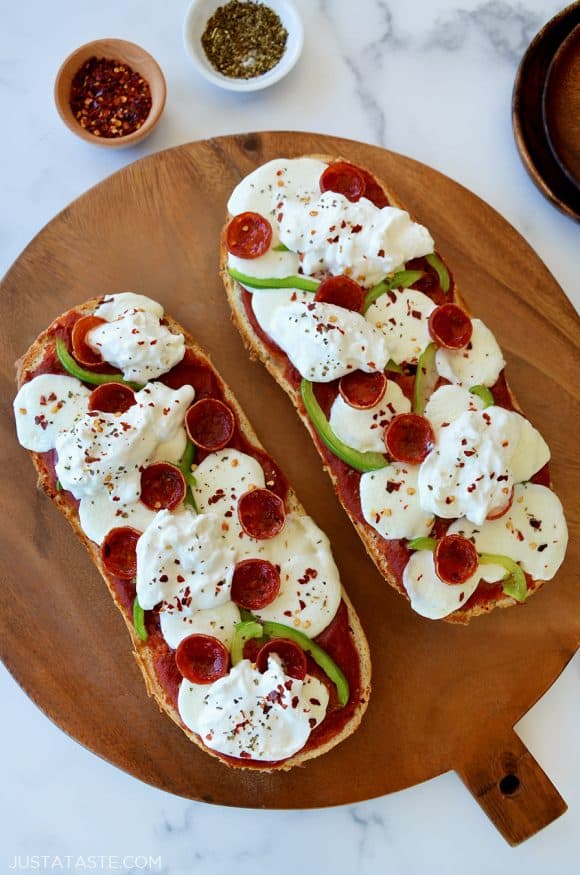 The Best French Bread Pizza with Burrata on wooden cutting board