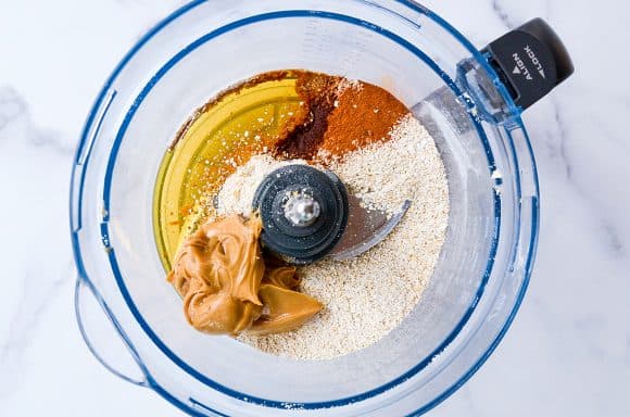 Food processor containing oat flour, peanut butter, honey and ground cinnamon