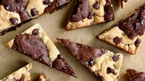 Brookies (chocolate chip cookie brownies) cut into triangles and topped with large flake sea salt.