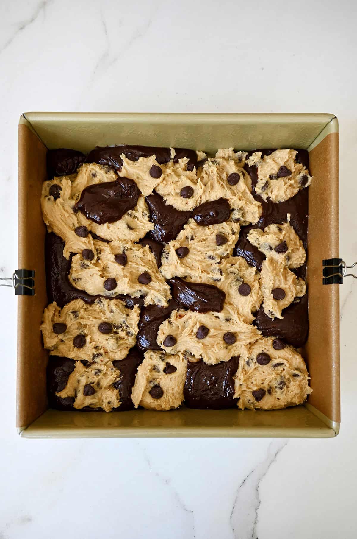 Chocolate chip cookie dough marbled together with fudgy brownie batter in a pan.