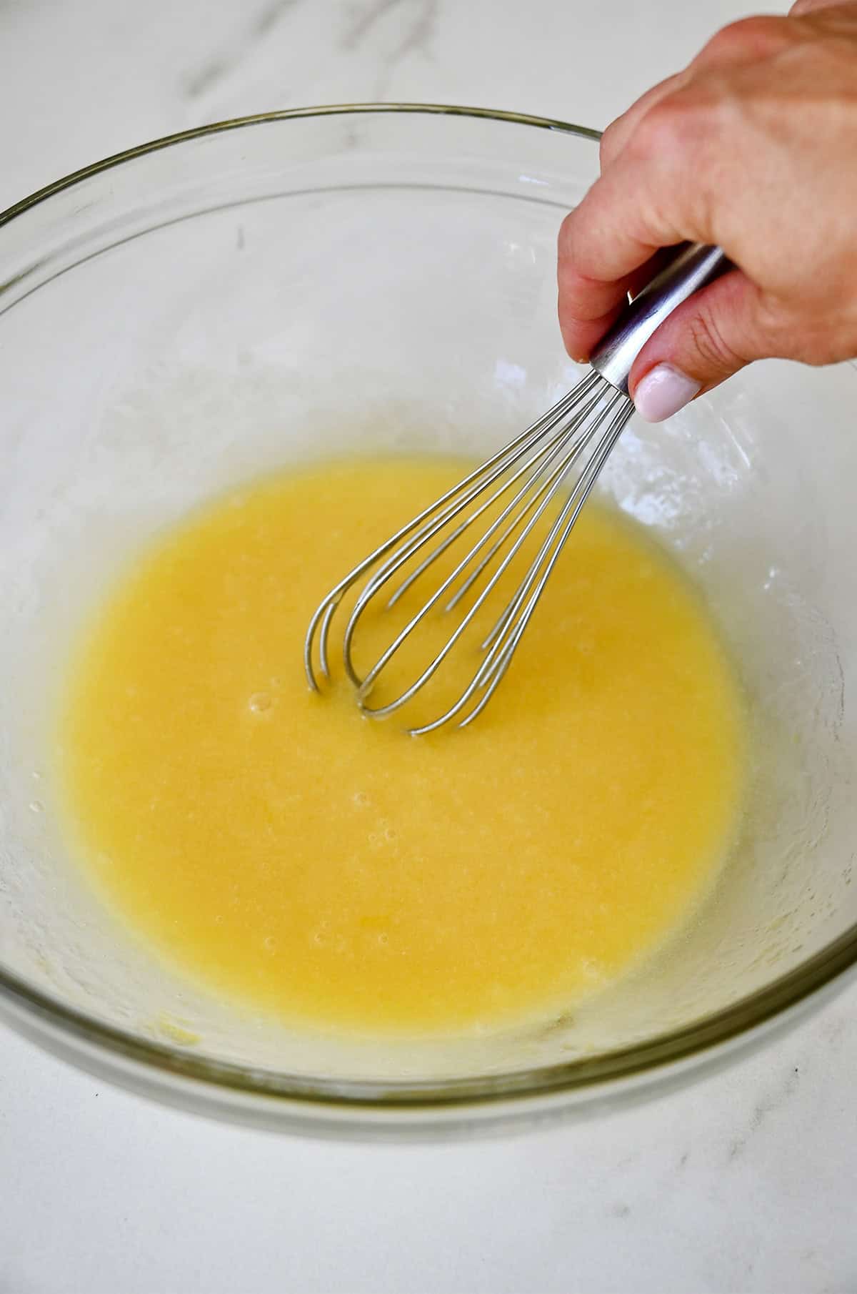 Oil, melted butter, sugar, vanilla extract and an egg, whisked together in a bowl.