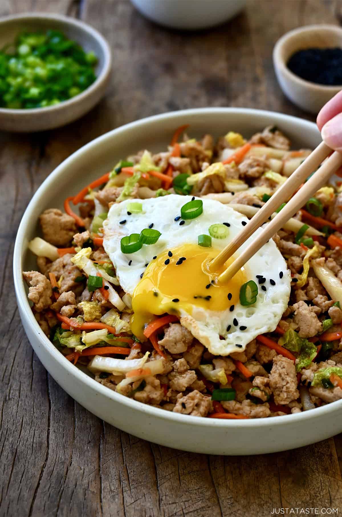 Egg roll bowl topped with a fried egg with runny yolk.