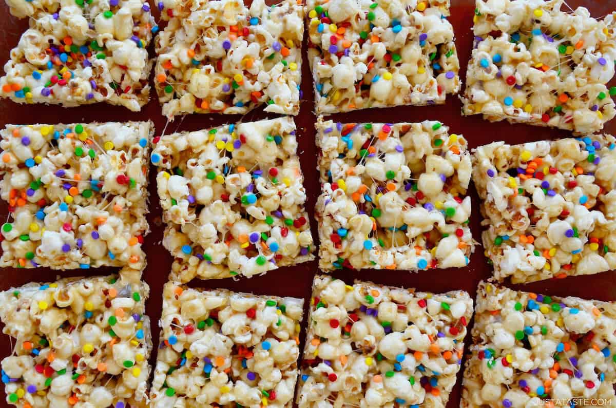 Marshmallow popcorn with rainbow sprinkles cut into squares.