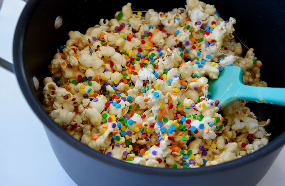 Popcorn coated in melted marshmallows and butter in a pan.