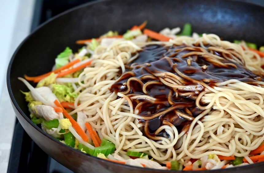 Chow mein sauce over noodles and veggies in a large skillet