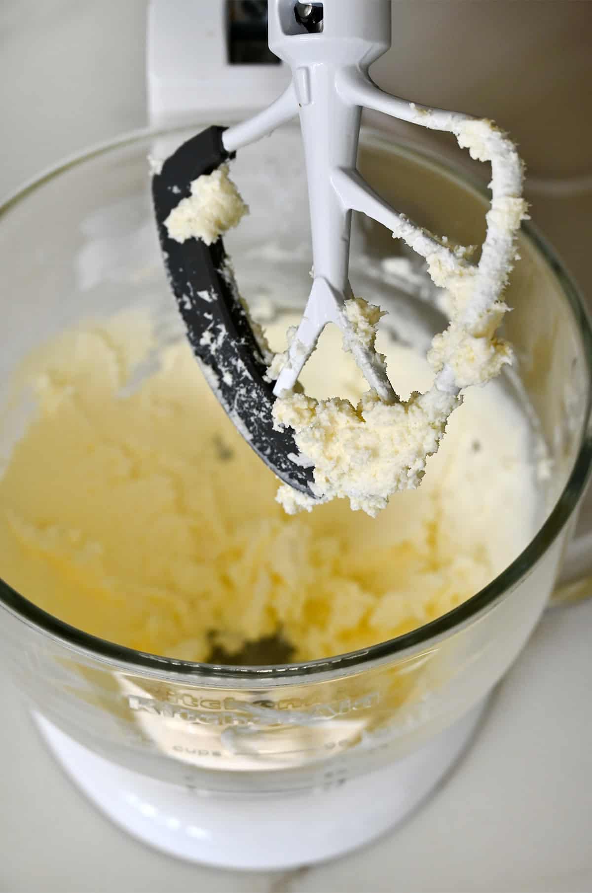 Cream butter and cream cheese in a stand mixer bowl with the paddle attachment.