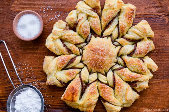 An overhead shot of a puff pastry snowflake dusted with powdered sugar