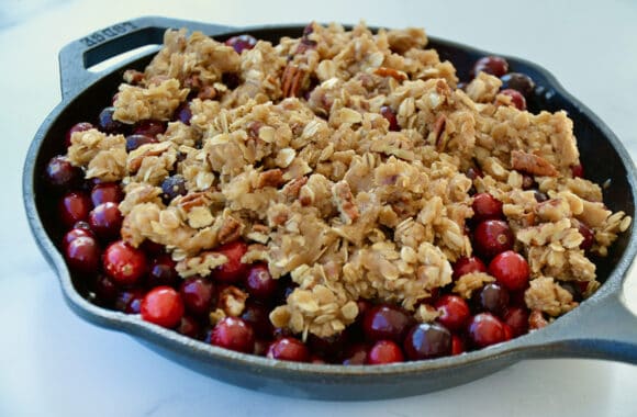 A skillet containing cranberries with crisp topping