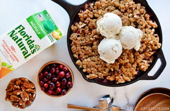 An overhead shot of a skillet containing cranberries and topped with ice cream