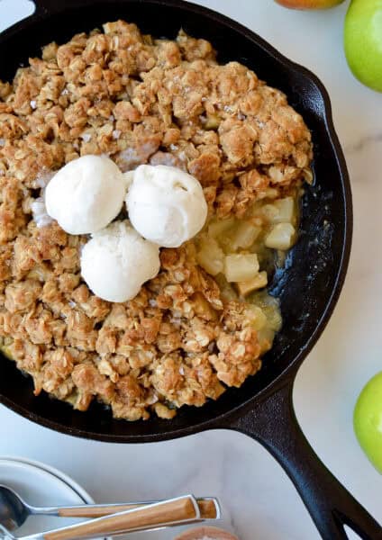 Apple pear crisp topped with three scoops of vanilla ice cream.