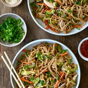 A top-down view of two bowls containing Quick Chicken Chow Mein and chopsticks
