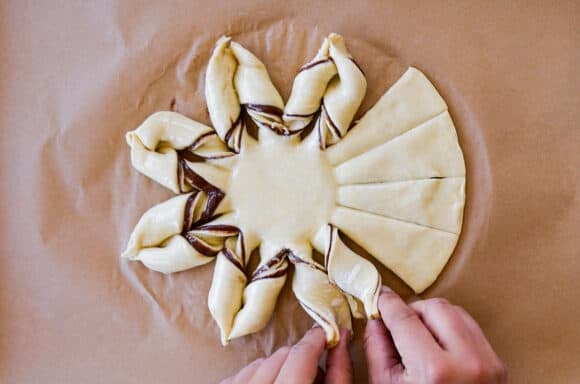 Twisting sheets of puff pastry into a snowflake