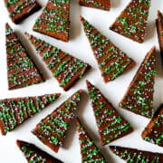 A top-down view of Christmas Brownies drizzled with chocolate and studded with white and green sprinkles.