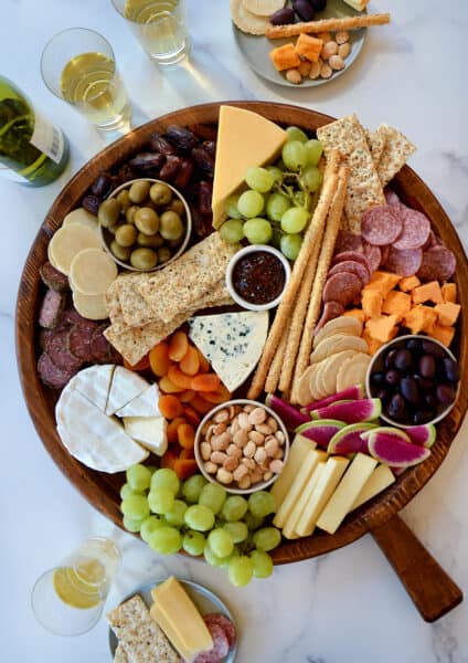 A top down view of a charcuterie board filled with meat, cheese, fruit and crackers