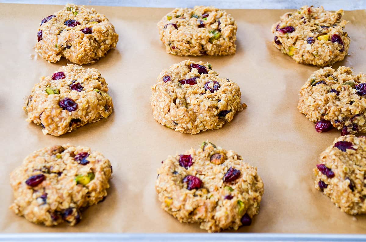 Unbaked breakfast cookies on a parchment paper-lined baking sheet.