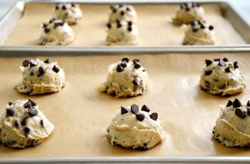 Scoops of cookie dough on a parchment paper-lined baking sheet