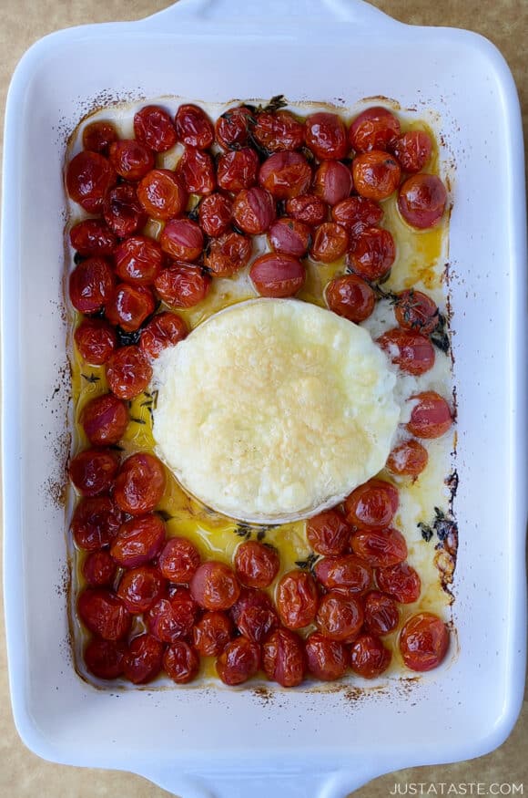 A top-down view of baked brie and roasted tomatoes in a baking dish