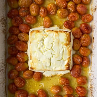 Baked feta in a baking dish with tomatoes