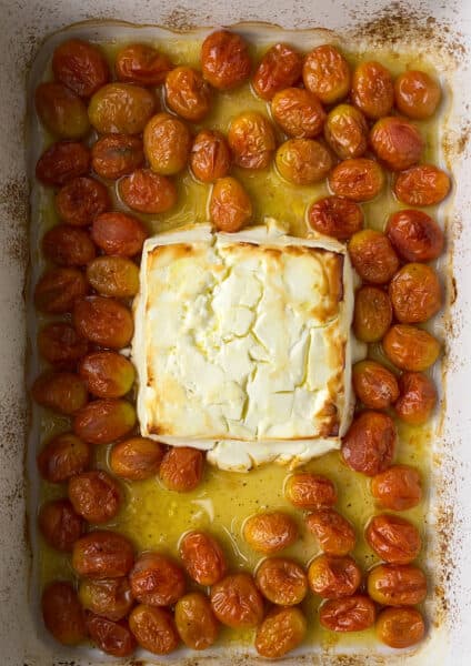 Baked feta in a baking dish with tomatoes