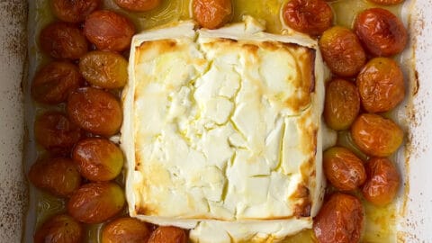 Baked feta in a baking dish with tomatoes