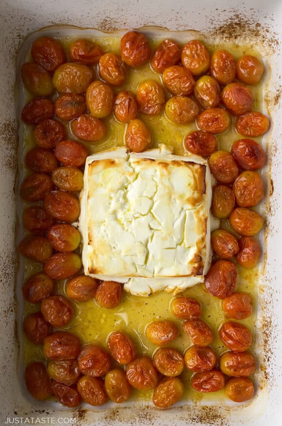 Baked feta in a baking dish with tomatoes